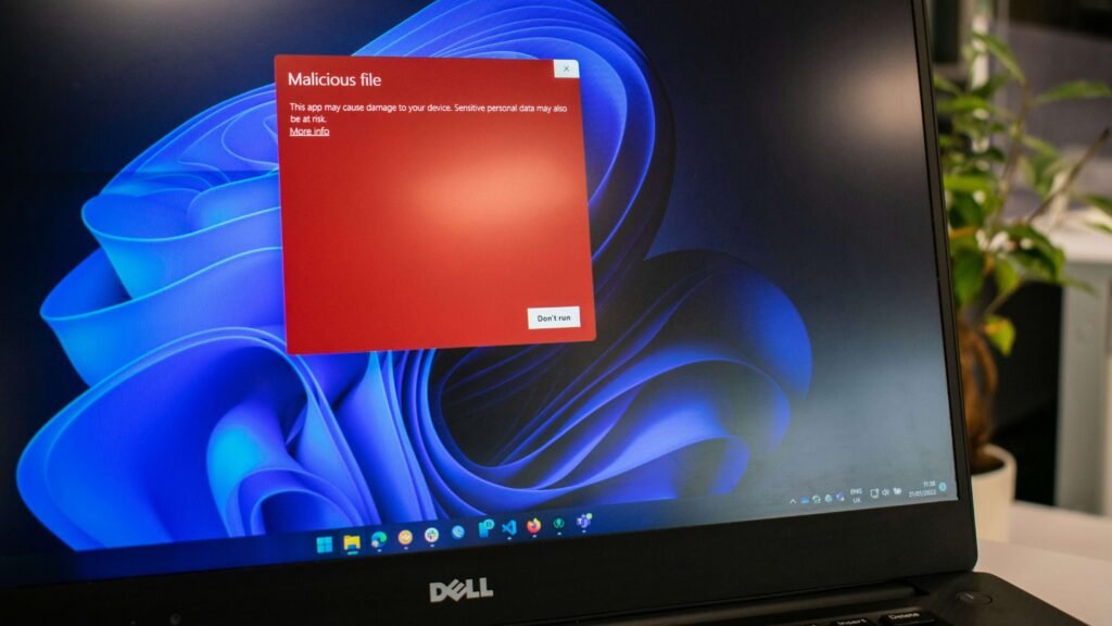 A dark cyber security visual showing a red warning shield on a laptop screen warning about streaming malware.