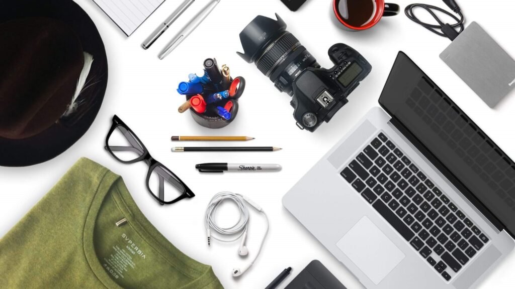 Flat lay of digital creator tools and devices representing how to make money with artificial intelligence by selling digital products