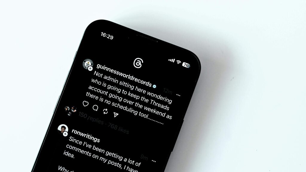 Smartphone screen close-up displaying dark mode post on the Threads app by Guinness World Records.