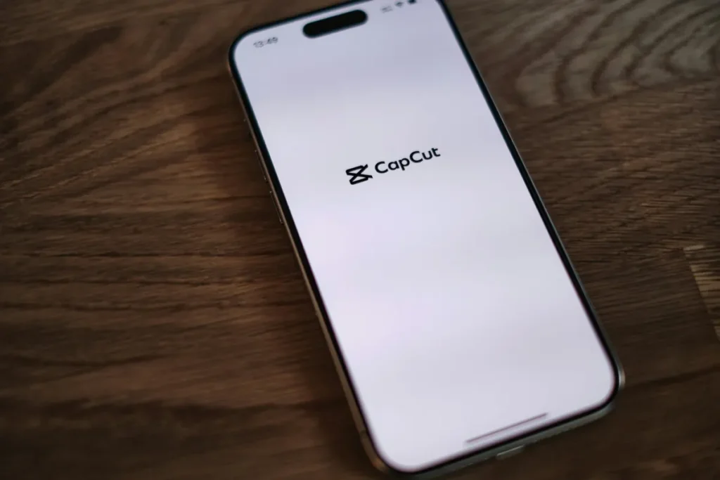 CapCut app open on an iPhone on a wooden table, the top pick among the best free video editing apps
